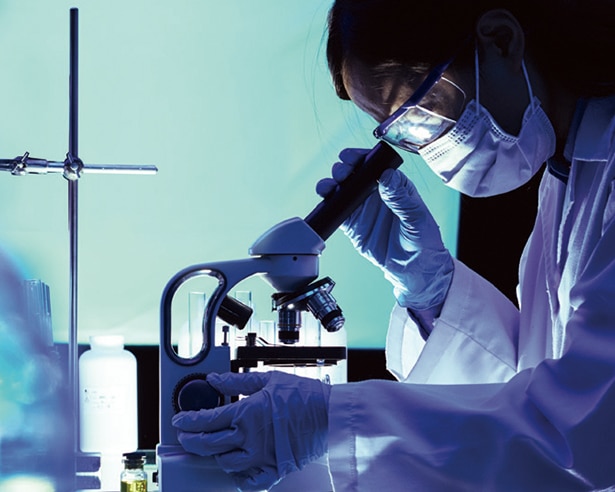 Person in a lab looking into a microscope