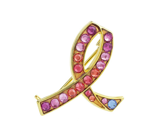 A blue stone is added to the Estée Lauder Jeweled Pink Ribbon Pin to represent the 1% incidence of breast cancer cases in the United States that are diagnosed in men.